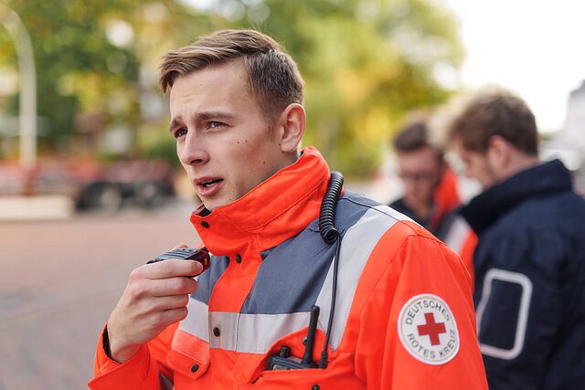 Einsatzkraft der DRK-Bereitschaft spricht in ein Funkgerät