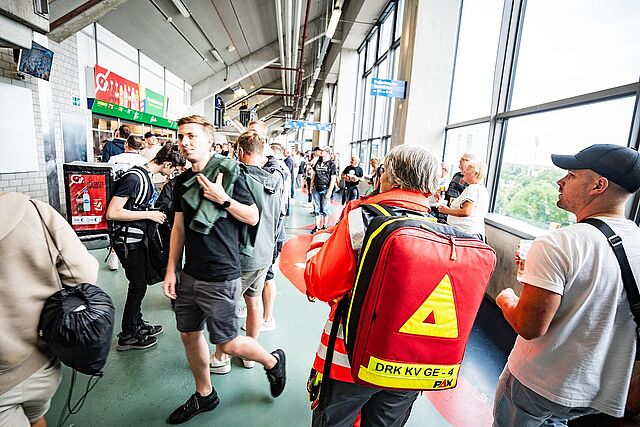 Sanitäterin mit Notfallrucksack im Umlauf eines Fußballstadions